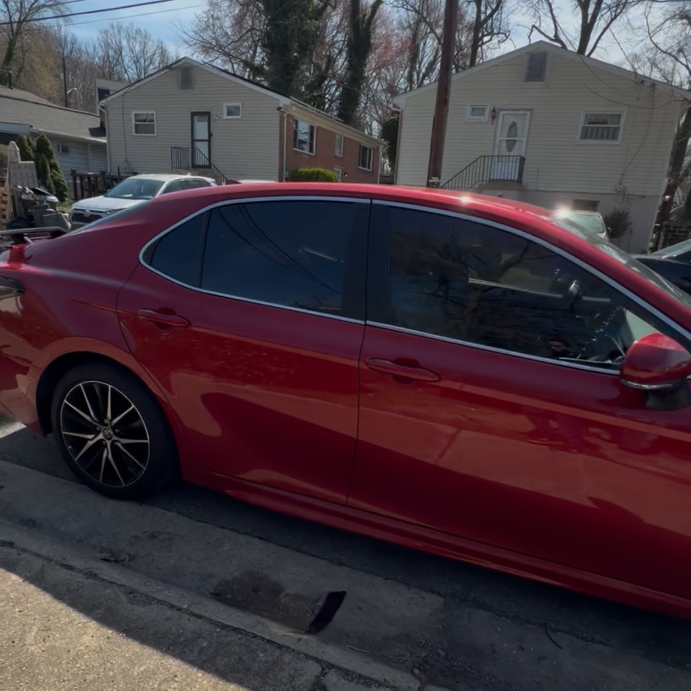 Red sedan after tint with finished dark side windows